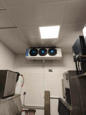 a room with a lot of appliances and a ceiling mounted air conditioner