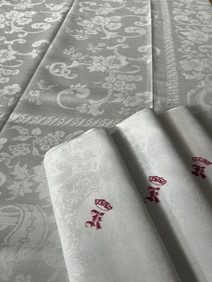 une table recouverte d'une nappe blanche ornée de motifs rouges