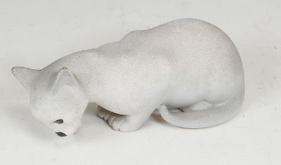 a white cat figurine sitting on a white surface