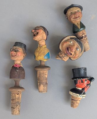 cinq figurines en bois représentant différentes personnes, posées sur une table