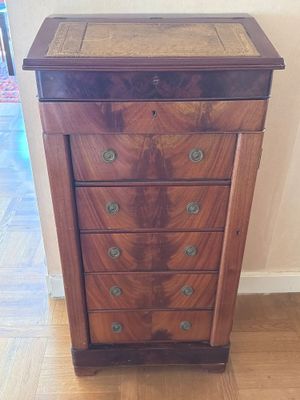 une petite commode en bois posée sur un parquet en bois dur