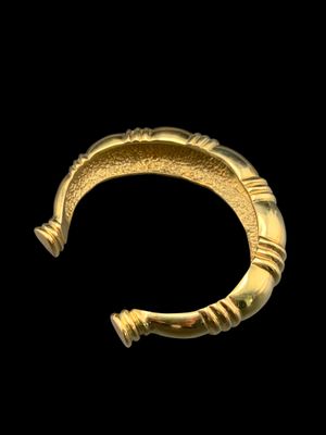 gros plan d'un bracelet en or sur fond noir