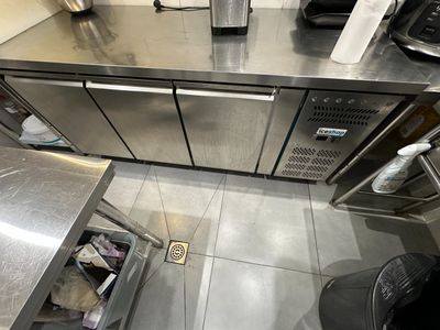 un plan de travail en inox équipé d'un micro-ondes et d'une cafetière