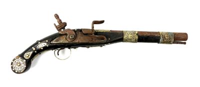 un vieux fusil exposé sur une surface blanche