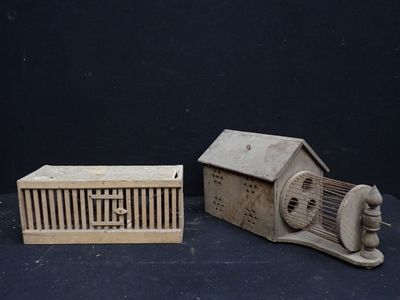 une petite cage à oiseaux et un petit nichoir posés sur une table