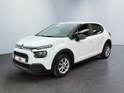 Une Citroën blanche est garée dans une pièce blanche