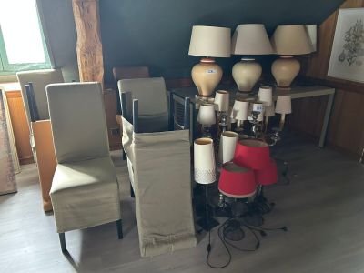 une pièce avec beaucoup de chaises et de lampes posées sur la table