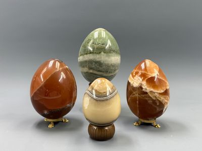 trois œufs de couleurs différentes posés les uns à côté des autres sur une table