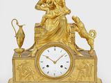 une horloge en or ornée d'une statue représentant une femme et un chat