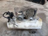 un petit compresseur d'air posé par terre dans le garage