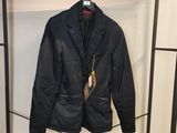 une veste noire suspendue à un porte-manteau dans une pièce