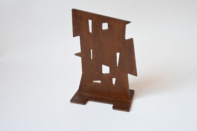 une petite sculpture en bois représentant un voilier sur une surface blanche