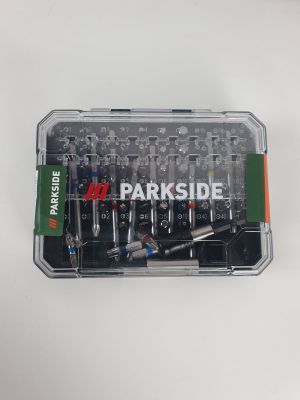 un boîtier en plastique contenant des vis, posé sur une surface blanche