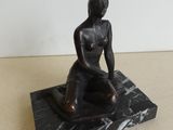 statue d'une femme assise sur un socle en marbre