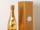 une photo représentant une bouteille de champagne posée à côté d'une boîte sur une table