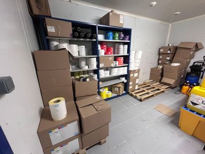 une pièce remplie de cartons et de palettes dans un entrepôt