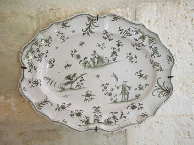 MOUSTIERS Plat en faïence chantourné à décor polychrome de g…