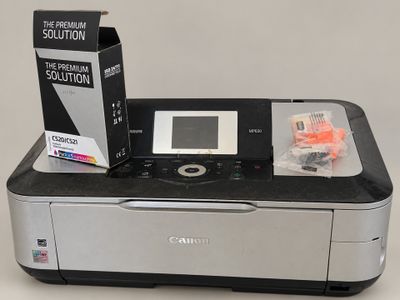 a canon printer sitting on top of a table next to a printer