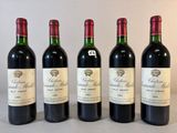 quatre bouteilles de vin rouge sont alignées sur une table
