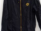 black jacket with gold logo on the chest and a pair of white sneakers