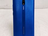 the back of a blue phone on a white surface