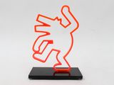 an orange neon sculpture of a bird on a black base