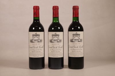 trois bouteilles de vin rouge posées côte à côte sur une table