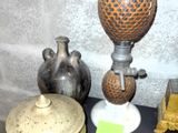 de nombreux vases de toutes sortes posés sur une table noire, accompagnés d'une étiquette jaune