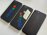 trois iPhones noirs posés les uns à côté des autres sur une table