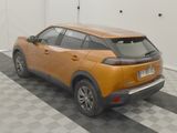 an orange car parked in a garage with a checkered floor
