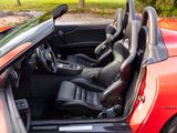 a red sports car with its doors open in a parking lot