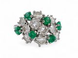 gros plan d'une bague en diamant et émeraude sur fond blanc