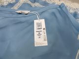 a close up of a blue dress with white lace on it