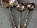 three spoons and two spoons sitting on a table