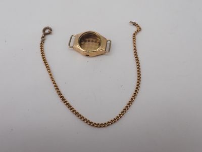 a close up of a watch with a chain on a white surface