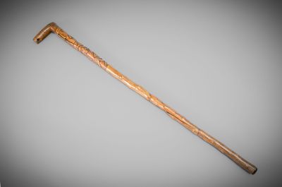 a close up of a wooden stick with a handle on a gray background