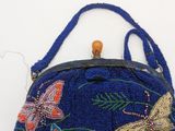 a blue beaded purse with a butterfly design on it