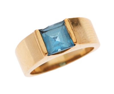 Gros plan sur une bague en or ornée d'une topaze bleue