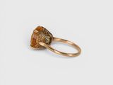 a close up of a gold ring with a brown stone