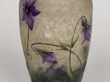 a vase with purple flowers painted on it on a white surface