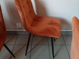two orange chairs sitting next to each other on a tiled floor