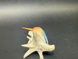 figurine of a sea shell with a bird on it ' s head