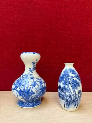 two blue and white vases sitting on a table