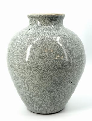 a gray vase that is sitting on a white surface