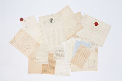 une pile de vieilles lettres, surmontée d'un sceau de cire