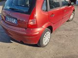 a small red car parked in front of a garage