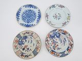 quatre assiettes à motifs différents posées sur une surface blanche