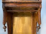 a wooden grandfather clock on display against a blue wall