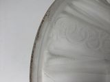 a glass vase with a white base on a white table