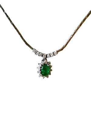 une image représentant un collier orné d'une pierre verte entourée de diamants